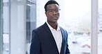 Face, business and a serious black man at a window in his office for professional work or career. Portrait, corporate and glasses with a confident young employee in a suit at his workplace in the day