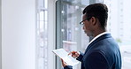 Businessman, tablet and research by window at office for communication, social media or networking. Black man or employee with technology for online search, browsing or schedule planning at workplace