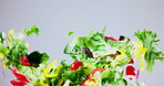 Vegetables, salad and tossing fresh produce on mockup space against a gray studio background. Clean veggies or mix for healthy meal, snack or diet for vegetarian, natural clean cut food or nutrition