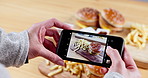 Person, hands and photography of fast food in restaurant, cafe or burger meal for snack, picture or vlog. Closeup of woman or photographer taking photographs or snaps of lunch, dinner or hamburger