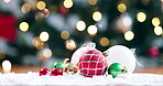 Christmas eve, celebration and festive with decorations on the floor for the holiday season for cheer. Event, december and baubles in snow in the living room of a home for tradition in winter closeup