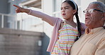 Happy, pointing and girl child with grandfather standing in garden of new family home. Smile, conversation and kid bonding with senior man in retirement by house, apartment or real estate together.