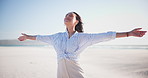 Beach, wind and woman in nature with open arms peace, breathing or freedom at the ocean. Travel, adventure and person with hands up at the sea for vacation, holiday or gratitude for life or fresh air