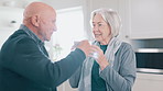 Senior couple, drinking coffee and kitchen at morning with mug, conversation and love in a home. Retirement, marriage and discussion with hot drink or tea together with a smile and happy chat