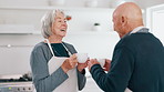 Senior couple, laughing and coffee in a kitchen in the morning with conversation and love in a home. Retirement, marriage and discussion with hot drink or tea together with a smile and happy chat