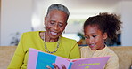 Grandmother, child and reading books on sofa for learning, language development or care for knowledge in living room. Happy senior woman, kids and black family relax for storytelling together at home