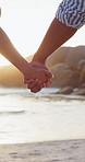 Love, freedom and couple holding hands at a beach for travel, support and adventure, break or bond closeup. Zoom, vacation and people in nature for vacation, holiday or adventure, journey or romance