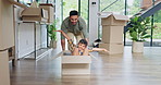 Happy dad, box and playing with boy in new home for real estate, bonding or property investment. Father and pushing child with smile for fun playful relocation, renovation or moving in house together