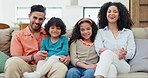 Love, smile and face of parents and kids on a sofa for bonding and relaxing together at home. Happy, care and young Indian mother and father with children in the living room of modern house.