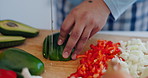 Cooking, food and hands with knife in a kitchen with vegetables, avocado and health meal prep. Person, diet and lunch in a home with salad, cutting wood board and chopping for dinner in a house