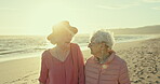 Senior women, talking and sunrise at beach, bonding and walking by shore or relaxing on holiday. Elderly friends, care and together for support in retirement, conversation and traveling in outdoors