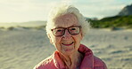 Senior woman, face and holiday on beach, smile and freedom on sand or relaxing on vacation. Elderly person, glasses and happy in portrait or confident in retirement, nature and traveling in outdoors