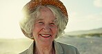 Senior woman, face and smile on beach, vacation and freedom on sand or relaxing on holiday. Elderly person, hat and happy in portrait or confident in retirement, nature and traveling in outdoors