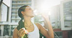 Woman drinking water, fitness and city for exercise, running break and health, energy or workout in lens flare. Young thirsty athlete, tired runner or sports person with a bottle for outdoor training