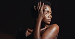 Face, hands and beauty with a natural black woman on a dark background in studio for feminine wellness. Portrait, skincare and spa with a young model touching her body or skin in satisfaction
