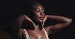 Face, hands and skincare with a young black woman on a dark background in studio for feminine wellness. Arms, beauty and spa with a confident natural model touching her body or skin in satisfaction