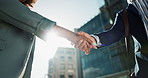 Outdoor, business people and professional with handshake, conversation and contract with lens flare, corporate and talk. Staff, employees in a city and coworkers with hello, partnership or urban town