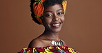 Happy, African fashion or face of black woman in studio on a brown background for trendy style. Smile, culture or model with confidence, pride or afro posing in wrap, clothes or traditional outfit
