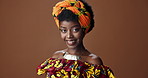 Wrap, fashion or face of happy black woman in studio on a brown background for trendy style. Smile, African or model with confidence, pride or afro posing in culture, clothes or traditional outfit