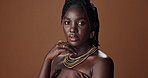 Black woman, beauty and fashion with skin in portrait, glow or shine with natural cosmetics on brown background. Dermatology, traditional style and African model with skincare for wellness in studio