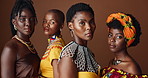 African fashion, face and black women in studio with stylish, beautiful and traditional outfits. Serious, pride and portrait of female people with trendy clothes for culture by brown background.
