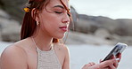 Woman, summer and typing with phone at beach for social media, reading notification and update travel blog for holiday. Gen z girl scroll on smartphone at ocean for vacation, mobile contact and relax