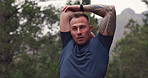 Man, stretching arms and fitness in forest for exercise, workout or thinking of energy for performance in nature. Serious, strong or agile runner warm up muscle for cardio, breathe or health in woods