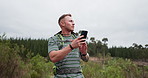 Search, phone and man hiking in a forest with travel, guide or navigation, directions or walking in nature. Smartphone, map and male backpacker with app for compass, location or tracking adventure