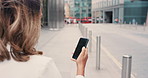 Unknown hispanic woman holding a phone in the city