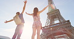 Carefree young couple celebrating in front of the Eiffel Tower