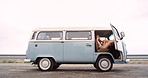 A young woman taking a break during a roadtrip to take photos using her camera while sitting in her camper van