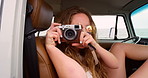 Cheerful young woman laughing while looking at photos she's taken with her digital camera