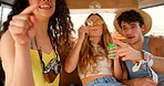 A group of excited friends blowing and popping bubbles in their camper van