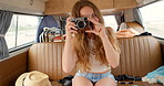 A cheerful young woman having fun taking pictures in her van during her holiday