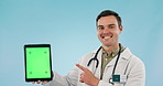 Doctor, medical and tablet green screen for clinic presentation, website or registration in studio. Face of healthcare man for digital mockup, telehealth service or tracking marker on blue background