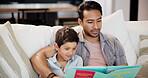 Family, reading and son with father on sofa in living room of home together for learning or literature. Education, storytelling book or child development with parent and boy child in apartment