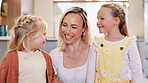 Happy family, talking and love in living room, bonding together and chat on weekend break in house. Young girls, mother and smile in discussion with care, positive and sweet in embrace in modern home