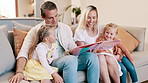 Parents, girl children and book on sofa for reading, learning and development with care, love and bonding. Mom, dad and kids with storytelling with teaching, support and talk on lounge couch in house