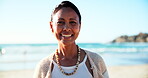 Woman, face and happy for vacation on beach, nature and  relax in summer for travel adventure. Indian person, positive and portrait on holiday in cape town, sunshine and trip to ocean for wellness