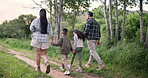 Holding hands, walking or family hiking in forest to relax on holiday vacation together in nature. Children siblings, mother or back of father in woods trekking on outdoor adventure for love, care