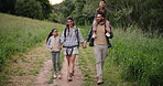 Holding hands, walking or family hiking in nature to relax on holiday vacation together in forest. Children siblings, mother or back of father in woods trekking on outdoor adventure for love or care