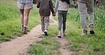 Parents, children and nature walking or holding hands on adventure journey for outdoor trekking, bonding or back view. Family, kids and forest path for vacation exercise or together, hiking or cardio