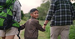 Boy, hiking in forest and smile with parents, bonding together and child with mom, dad and path. Hand holding, back and love with care, happy and backpack in nature for exercise, health and trail
