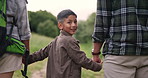 Boy, hiking outdoor and smile with parents, bonding together and child with mom, dad and path. Hand holding, back and love with care, happy people or backpack in forest for exercise, health or trail
