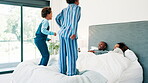 Parents, bed and children jumping in morning for playing wake up game for weekend excitement, vacation or happy. Man, woman and sibling leap in home or youth energy for bonding love, laugh or holiday