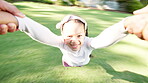 Face, smile and girl spinning in garden with parent for love, fun or bonding together as family. Portrait, energy or excitement and happy young kid swinging with hands on grass in backyard for trust