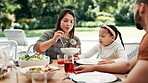 Family, thanksgiving lunch and mother with daughter at table outdoor for celebration or tradition. Love, food or vegetables with woman parent and girl child eating meal together at social gathering