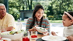 Family, thanksgiving meal and mother with daughter at table outdoor for celebration or tradition. Love, food or brunch with woman parent and girl child eating vegetables together at social gathering