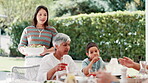 Woman, serving and family lunch outdoor for holiday celebration together with grandmother, child or love. Female person, salad bowl and table for festive season at party eat, thanksgiving or vacation