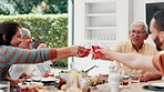 Family, toast for thanksgiving and parents with children at dinner table of home for celebration or tradition. Love, food and cheers with group of people eating meal together in apartment for holiday